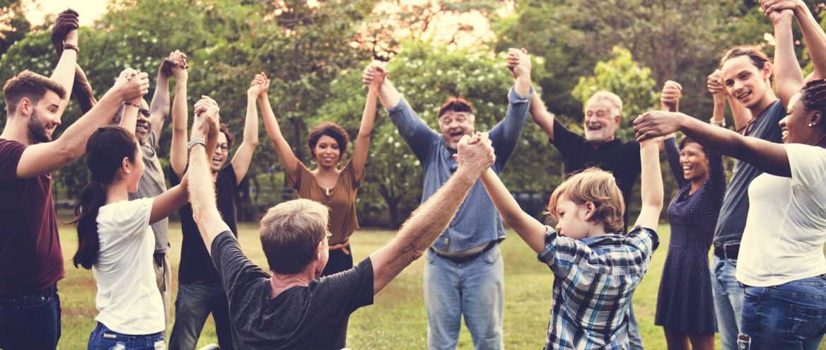 여러 사람들이 하늘을 향해 손을 마주 잡고 있는 사진