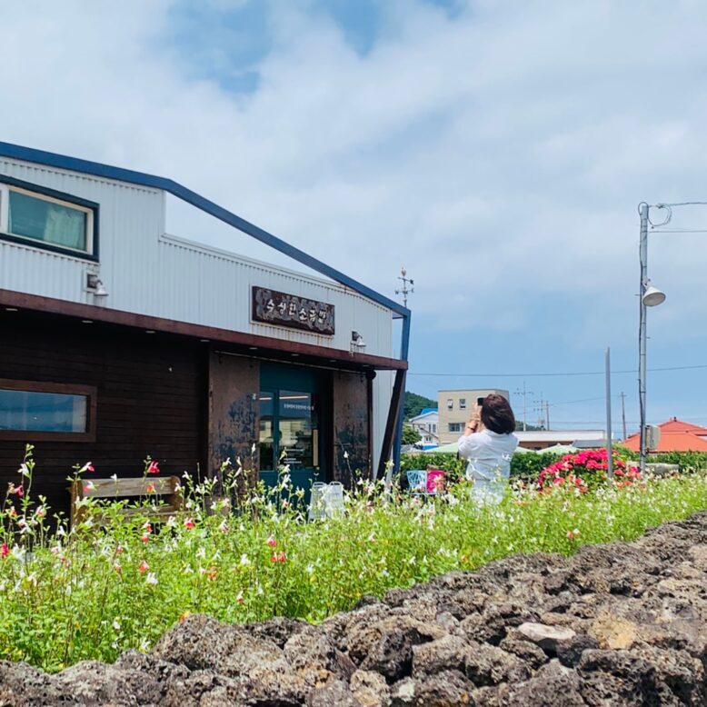 한 여성이 아름다운 들꽃이 핀 장소에서 서 있는 사진