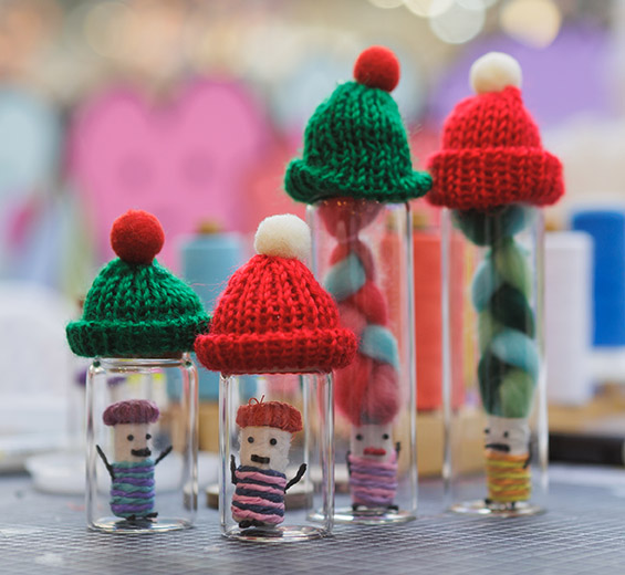 산타 모자를 쓴 조그만 병에 담긴 4개의 걱정 인형들 사진