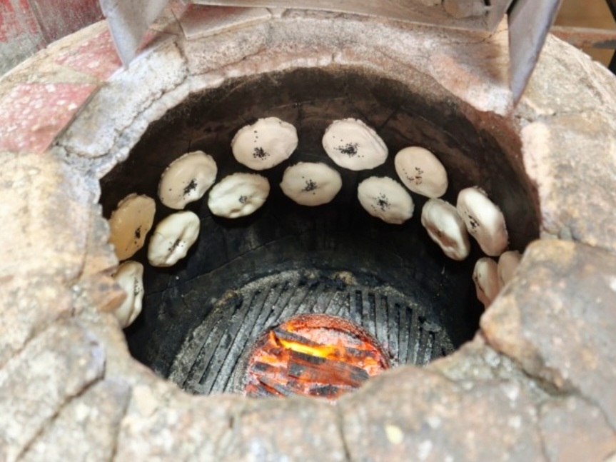 원형 화덕 안 벽에 붙어있는 만두의 모습