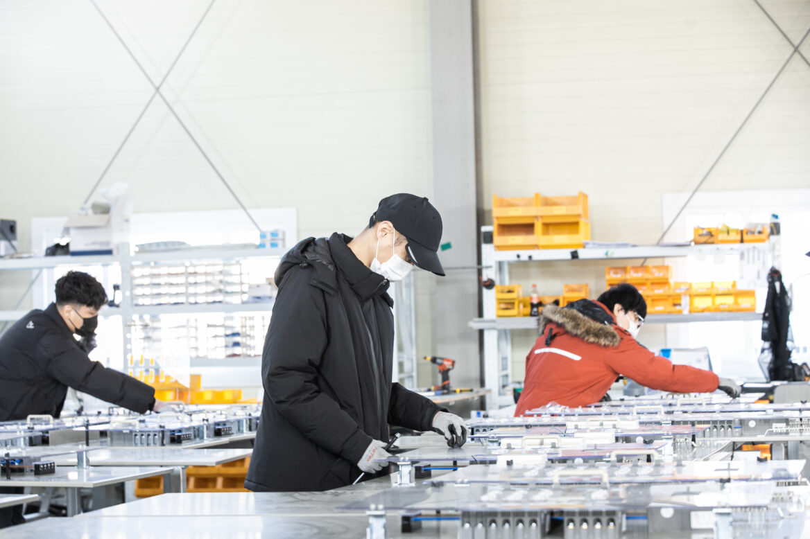 장갑과 마스크를 끼고 부품을 만지는 모습