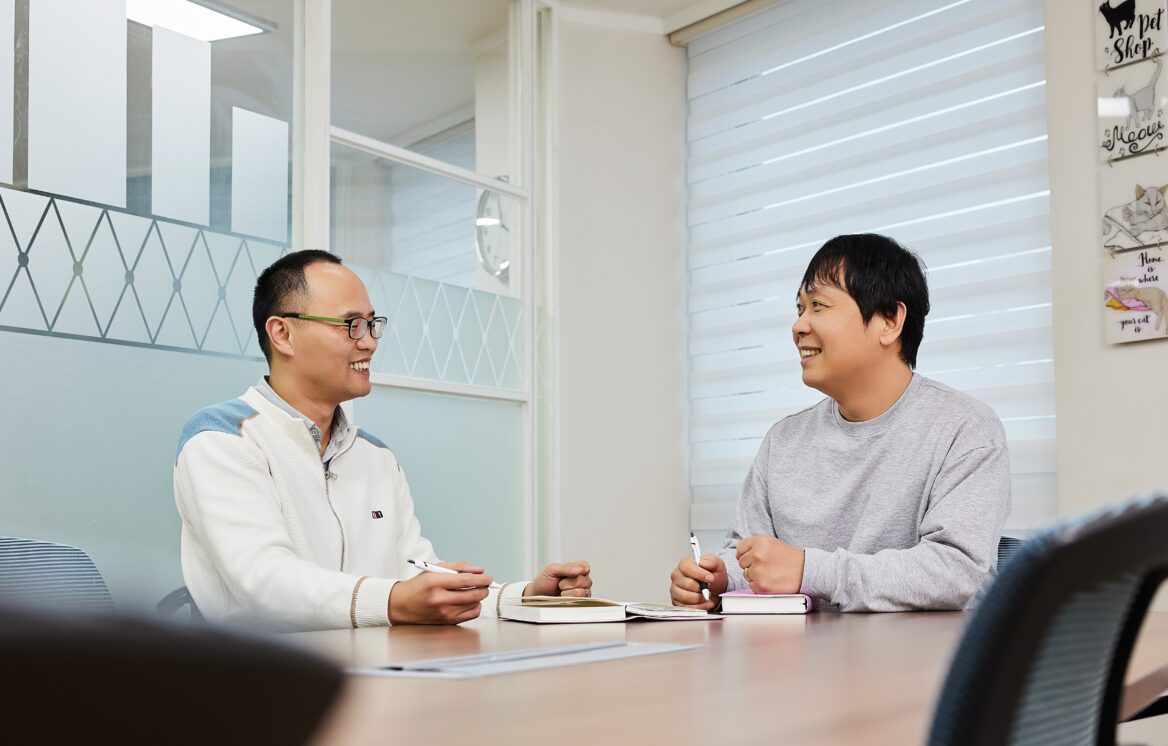 시각장애인인 김명섭 선임연구원이 동료 직원과 업무에 관해 상의하는 모습