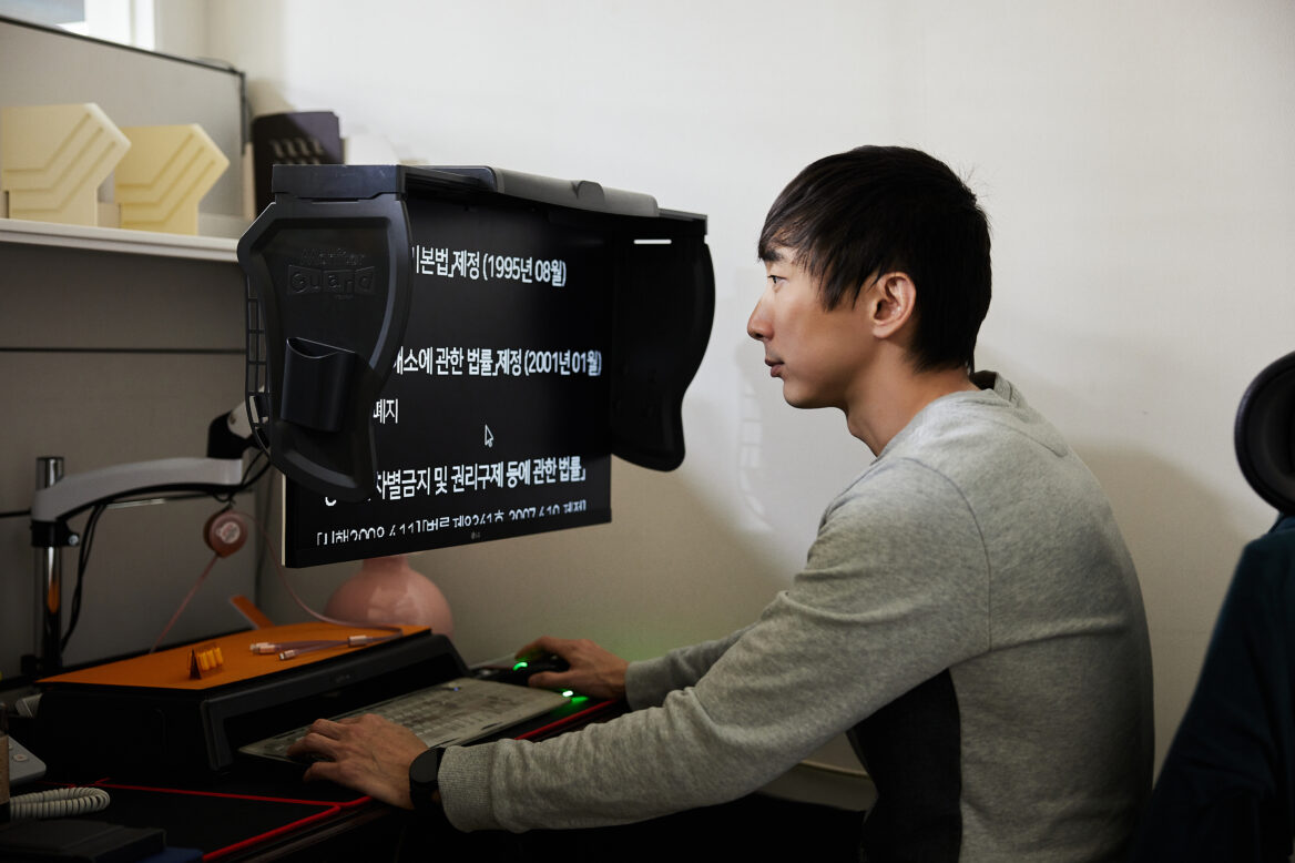 모니터 빛가림막이 설치된 컴퓨터를 사용해 웹 접근성을 심사하는 오정훈 부장