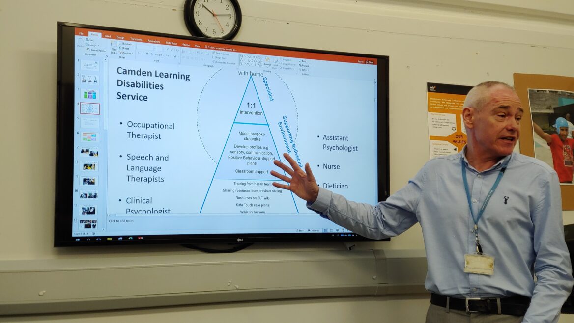 ‘중증장애인훈련센터’에서 선생님이 직업훈련 커리큘럼을 소개하고 있는 모습