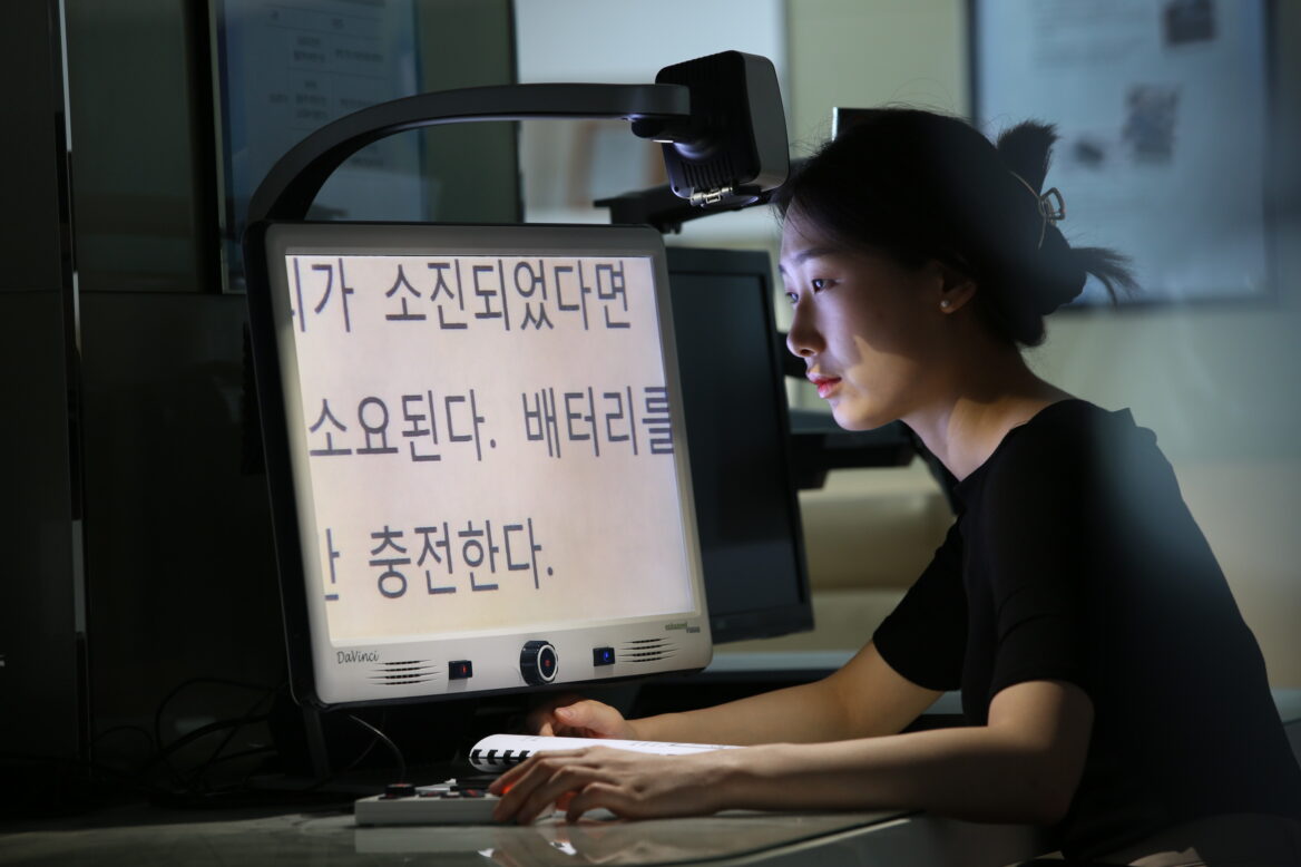 저시력 확대경 보조공학기기를 체험하는 모습의 사진