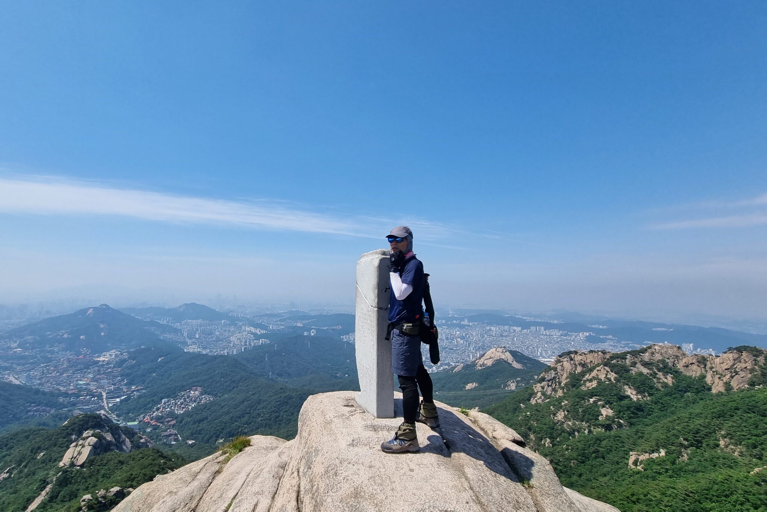 한정재 상임이사가 산 정상 바위에서 서있는 모습의 사진