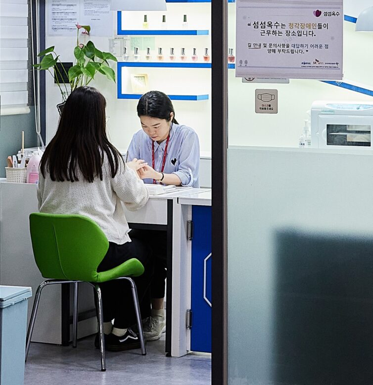 김아론 네일아티스트가 고객에게 네일을 해주고 있는 모습의 사진