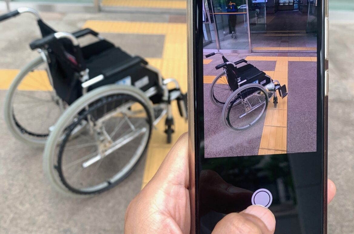 휠체어를 휴대폰 카메라로 찍고 있는 사진