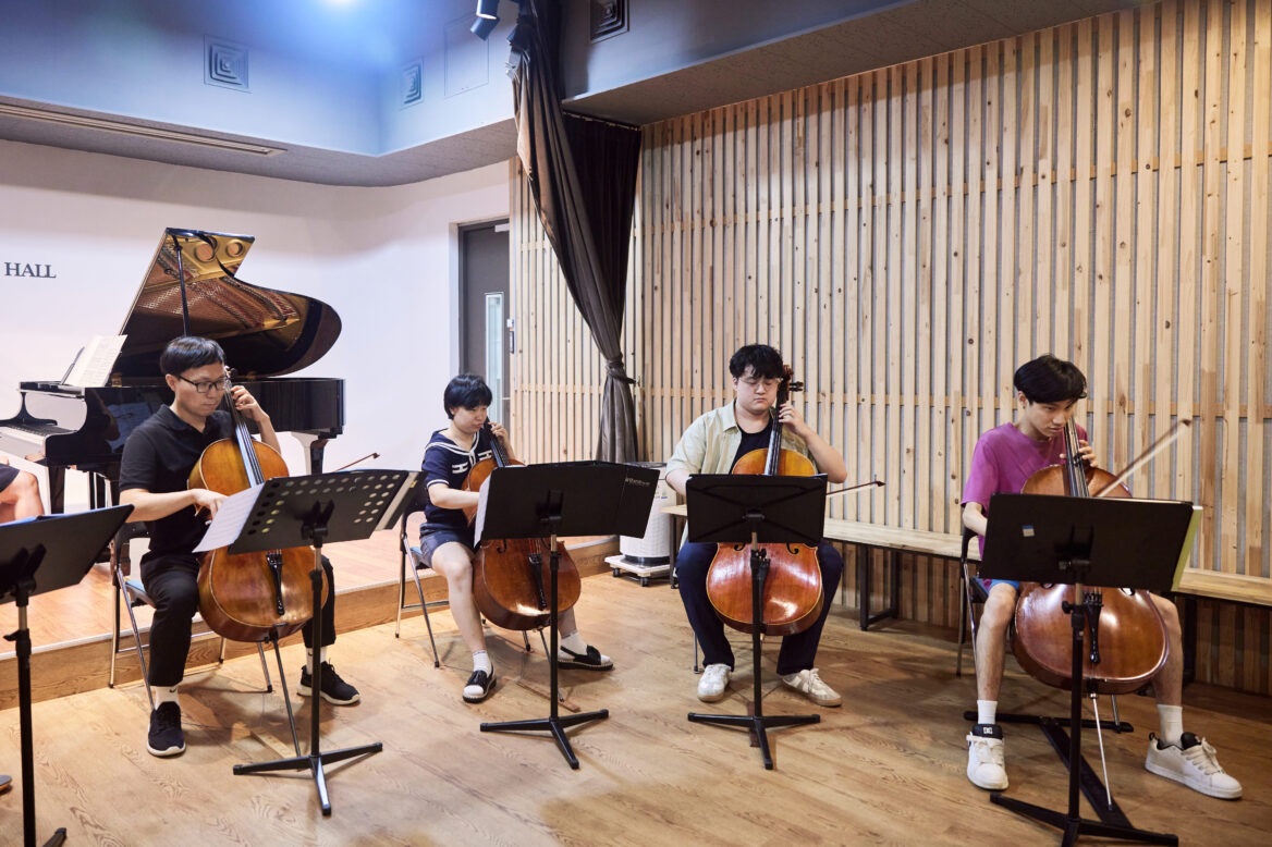 진지한 표정으로 첼로를 연주하는 단원들의 사진