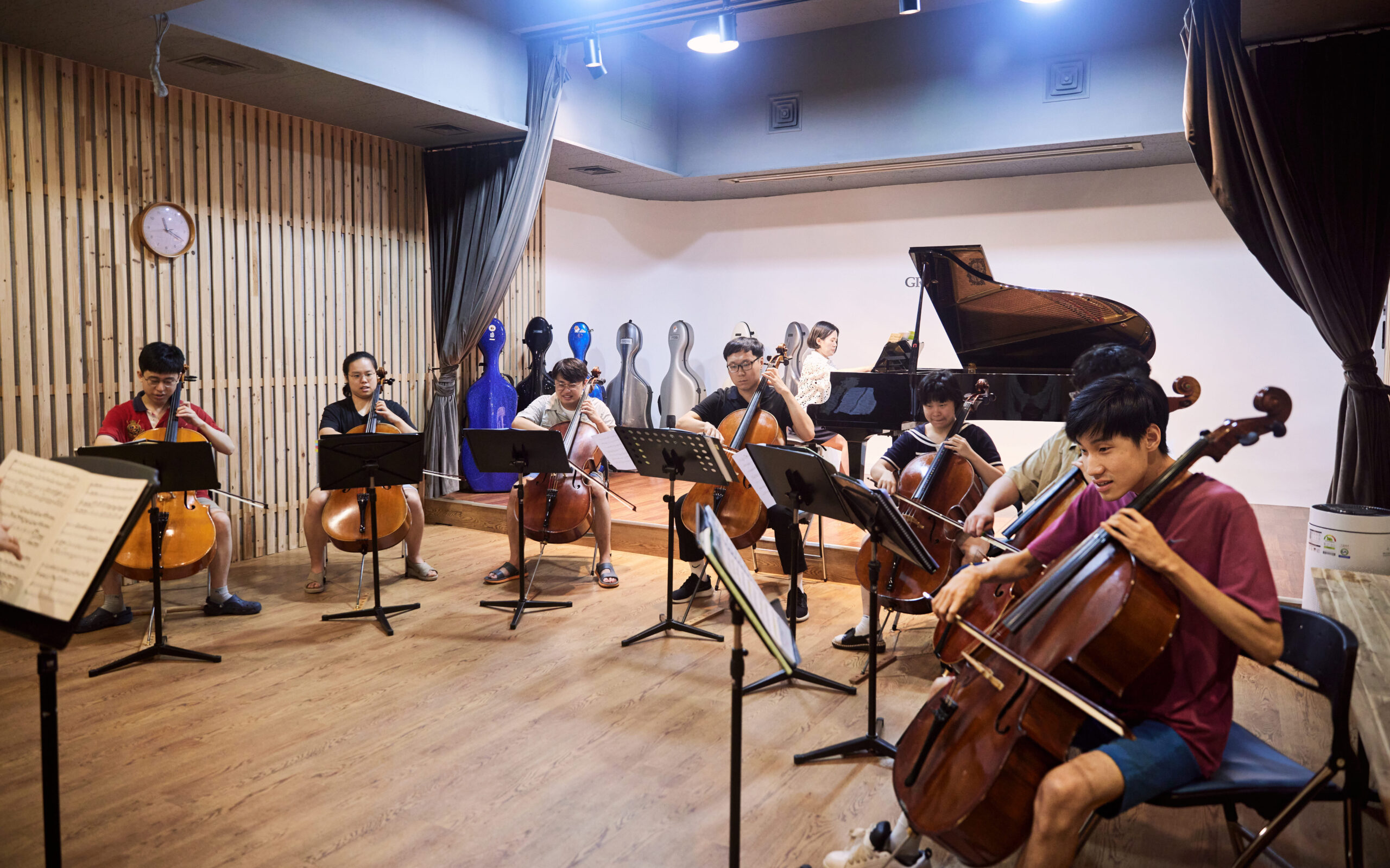 진지한 표정으로 첼로를 연주하는 단원들의 사진