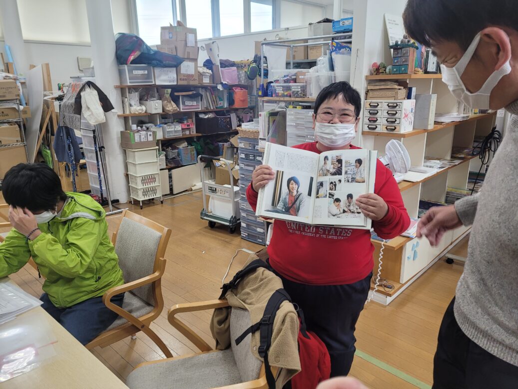 하나아트센터에서 일하는 장애인 근로자가 책을 펼치며 미소를 짓는 사진