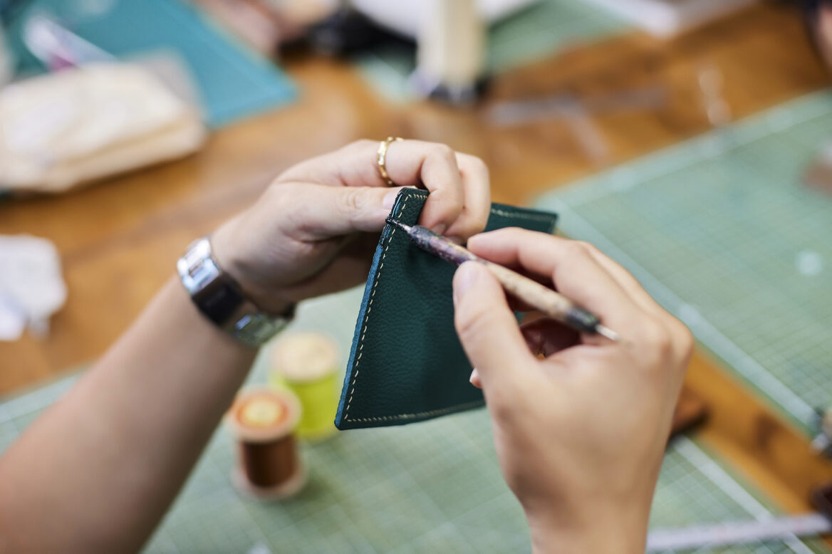 박보영 과장이 명함 카드지갑 선 위에 그리프를 대고 바느질 구멍을 뚫는 모습 사진