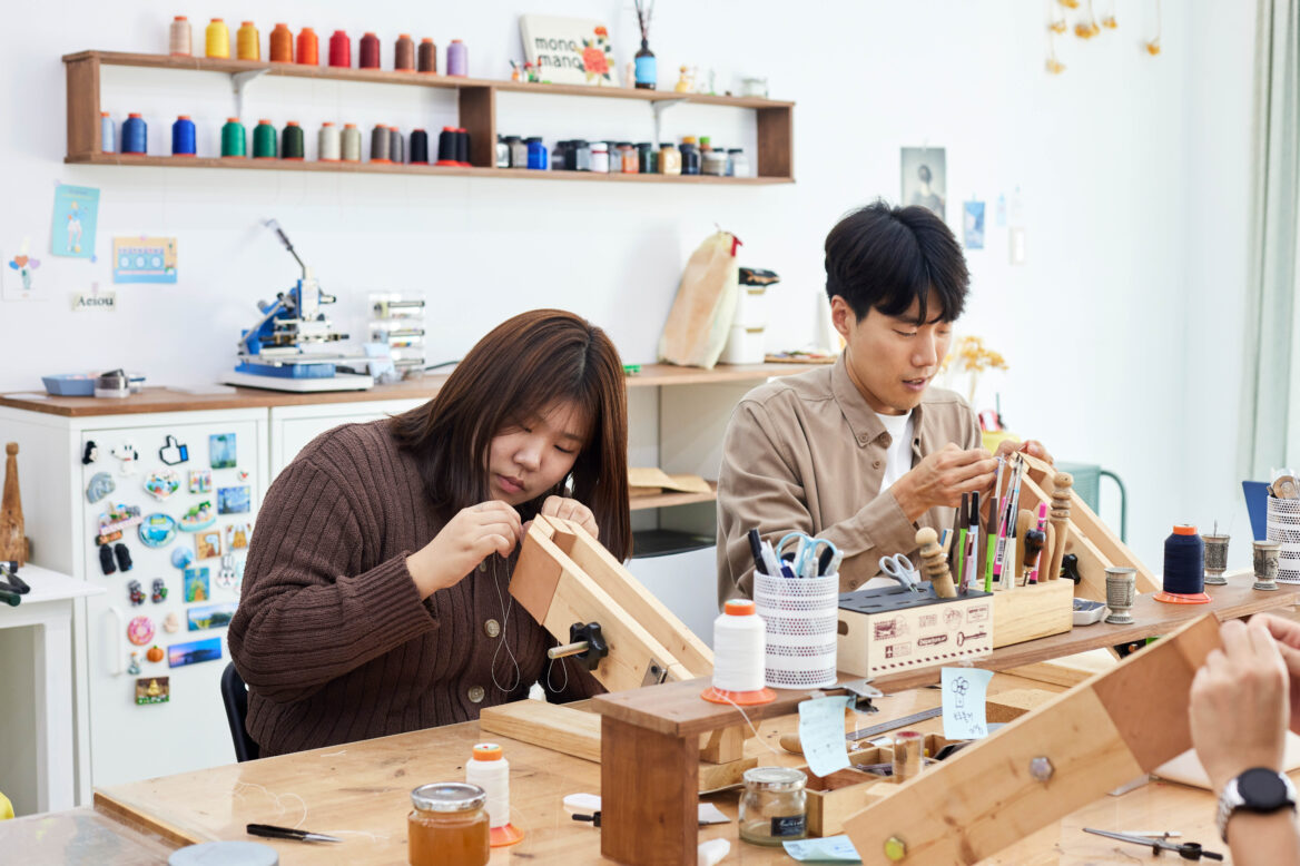 김헤석 대리와 장윤지 주임이 키링에 바느질 하고 있는 모습