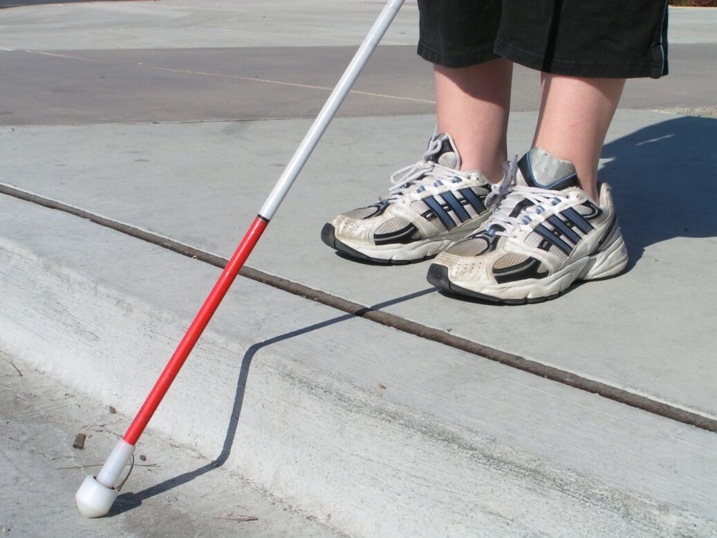 시각장애인을 상징하는 흰 지팡이를 짚고 있는 여성 사진