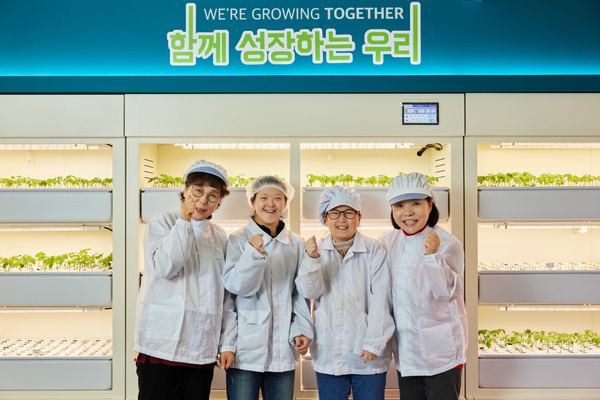 해피팜 협동조합 직원들이 정면을 바라보며 미소짓는 모습